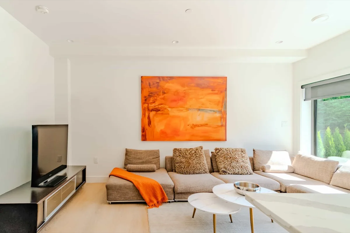 Bright Airbnb living room with orange artwork and natural light